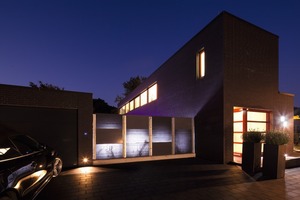  At night, the backlit light-transmitting concrete panels sharply contrast with the purely concrete panels  