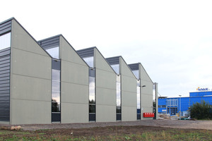  The new production hall (left) is flooded with daylight not least due to the striking roof architecture  