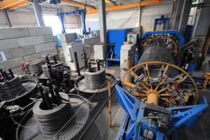  View from the front looking at the cage production line - on the left the coils with the longitudinal wires in four different diameters; the wires run to the blue ESR straightening and cutting machine placed behind; the VTA 160 cage welding machine on the right  