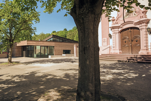  The new parish hall (at the back left) ideally matching the terrain and the existing buildings 