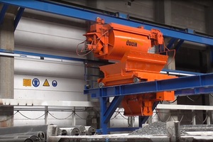  The new concrete distributor is conceived as a traveling portal solution. In the background: the bucket of the conveyor system with the lettering “Dudik”  