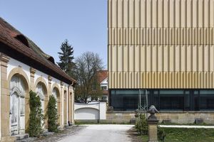  This concrete façade adopts the color of the neighboring sandstone buildings  