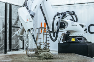  Der Kuka Roboter trägt mit gleichmäßigen Bewegungen aus einer großen Düse Spritzbeton auf den Gitterstahlkorb auf 