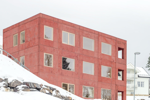  Sanden+Hodnekvam Arkitekter entwarfen ein Mehrfamilienhaus mit einer rötlichen Sichtbetonfassade im norwegischen Lillehammer 