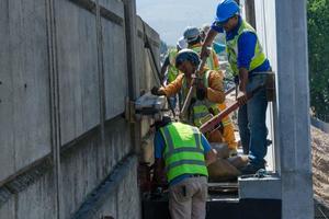  Workers involved with attachment of a precast concrete beam/balustrade unit to the rail bridge 