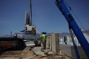  One of four precast concrete beam/balustrade units being lifted off the truck bed … 