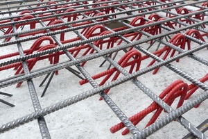 Workers in precast plants place the lattice girders like Filigran-Punching-Shear-Reinforcement parallel to each other on the lower bending reinforcement 