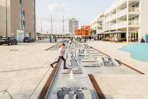  Mittig in der Priwall-Promenade wurde ein artifizieller Bach angelegt, der zum Spielen einlädt 