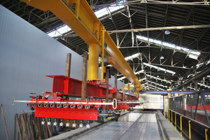  <div class="bildtext_en">A lifting crane then lifts half of the prestressed concrete beams out of the prestressing frame with a traverse and a special hook system</div> 