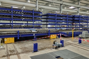  A lifting beam takes over the circulating pallet for the curing process and stacks them in the desired intermediate storage position on 