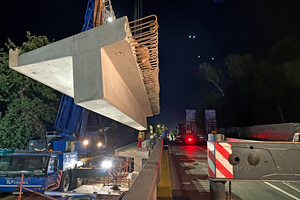  A precast T-beam is lowered into position by two mobile cranes 