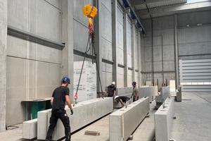  Fig. 4: View of the production hall: Shop-floor staff moving precast supports using a crane ...  