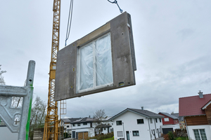  Fig. 4: The highly prefabricated concrete walls were installed on the construction site using a crane. Windows, insulation, and pre-installed building services were already integrated  