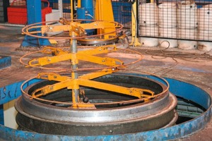  Fig. 3a and b &nbsp;The steel pallet is fixed on the vibration table while the reinforcement is fastened to the “Christmas tree”. Thereafter, the mold is moved into position and placed on top. 