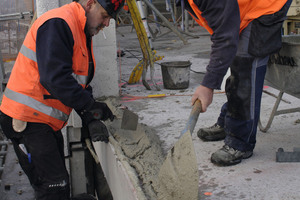  Die Betonfertigteilmonteure bereiten das Mörtelbett vor, in das das Fertigteil gestellt wird 