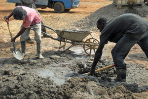  Manuelles Mischen mit Schaufeln auf dem Boden einer Baustelle in Lubumbashi/DRK 