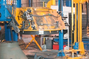  Fig. 3a and b  The steel pallet is fixed on the vibration table while the reinforcement is fastened to the “Christmas tree”. Thereafter, the mold is moved into position and placed on top. 