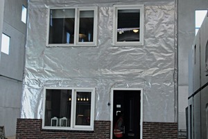  A two-story house in modular design and including gable roof has been assembled inside the factory building  