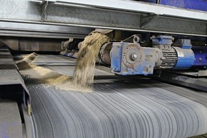  The hoppers containing the aggregates for the colored face concrete travel transverse to the movement direction across the belt conveyor transporting the aggregates to the block making machine 