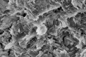  → 1 Scanning electron microscopic image of the pozzolanic reaction of metakaoline (solubilized particles above) in strength-building C-S-H phases 