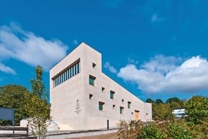  Der bemerkenswerte Kirchenbau sitzt am Rand eines Grünzugs und grenzt an Obstbaumwiesen 