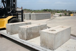  Already finished hollowcore floor slabs are waiting for their delivery at the back part of the storage yard; in front of the picture there are three concrete test blocks 