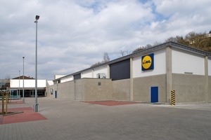  High-quality sandwich walls of fair-faced concrete with a Sinus design continue like a ribbon around this grocery and beverage store 