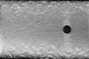  5CT image of a section level of a hardened SCC with 1.5 vol.-% steelfibers and  cylindrically shaped obstacle. The direction of flow in this image is from right to left 