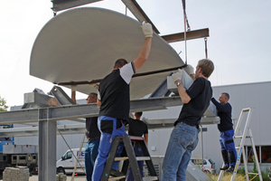  The workers allow the shell to slide gently along the sliding bearing, while still being attached to the crane 